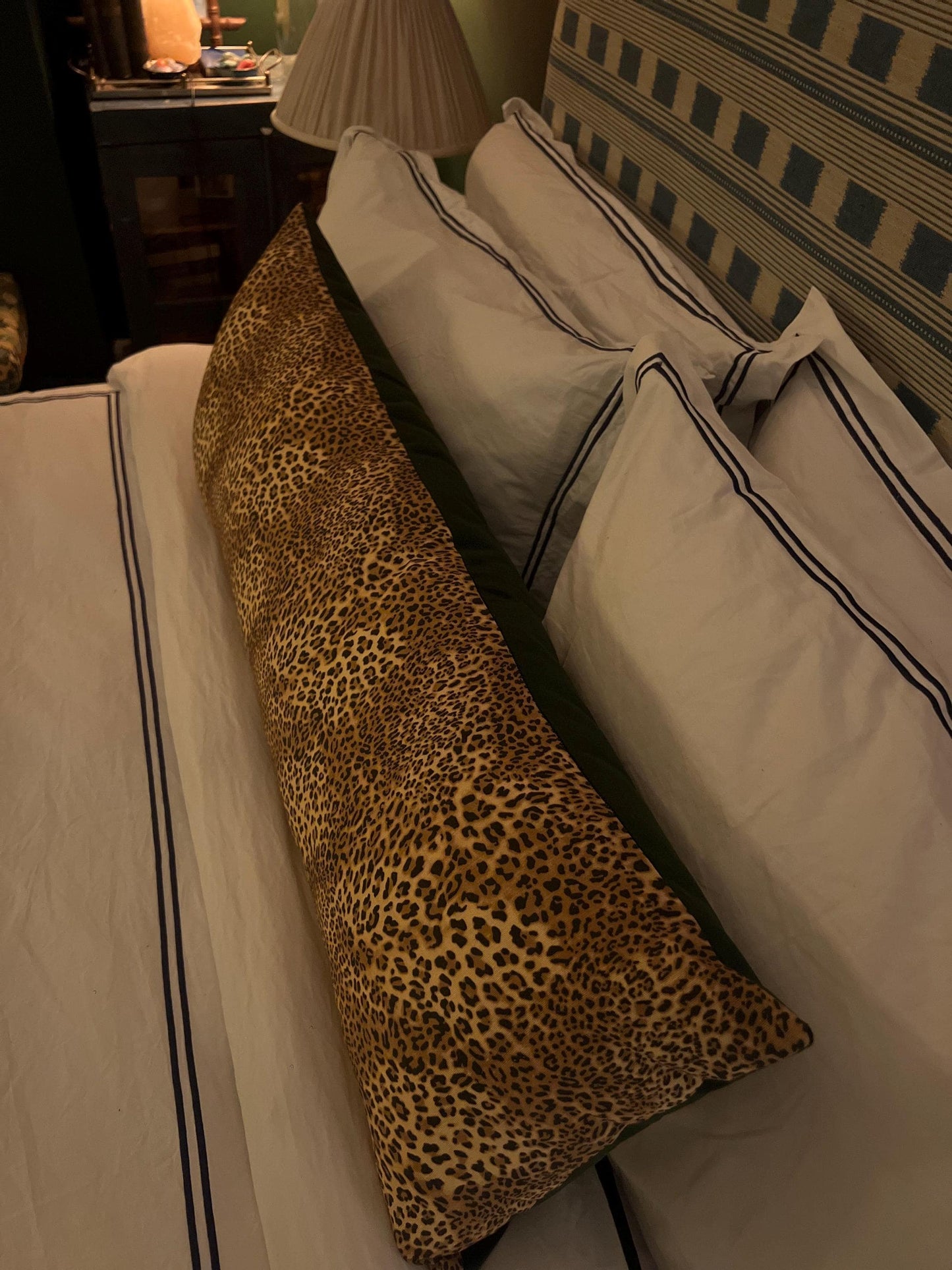 Large leopard print bolster cushions backed with green velvet backing