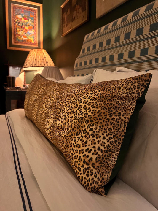 Large leopard print bolster cushions backed with green velvet backing